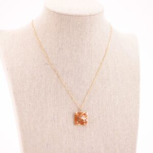Collar de acero dorado con detalles en color naranja, hipoalergénico y resistente al agua.
