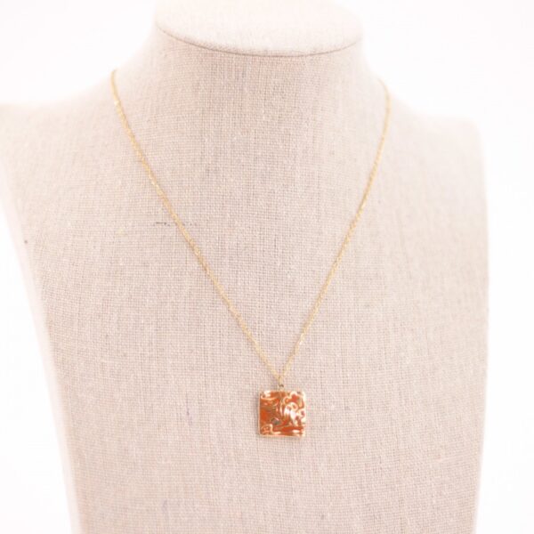 Collar de acero dorado con detalles en color naranja, hipoalergénico y resistente al agua.