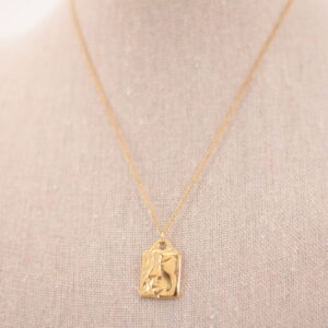 Collar de acero dorado con charm rectangular en forma de cara de mujer, hipoalergénico y resistente al agua.