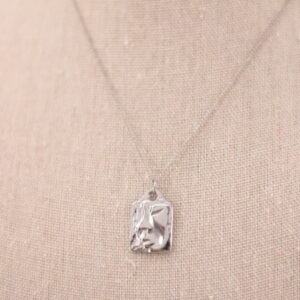 Collar de acero bañado en plata con charm rectangular en forma de cara de mujer, hipoalergénico y resistente al agua.